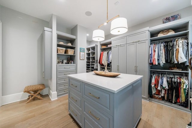walk in closet with light wood-style flooring