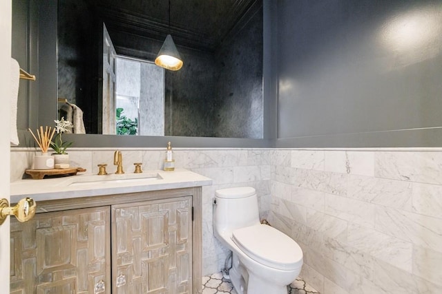bathroom featuring vanity, toilet, and tile walls