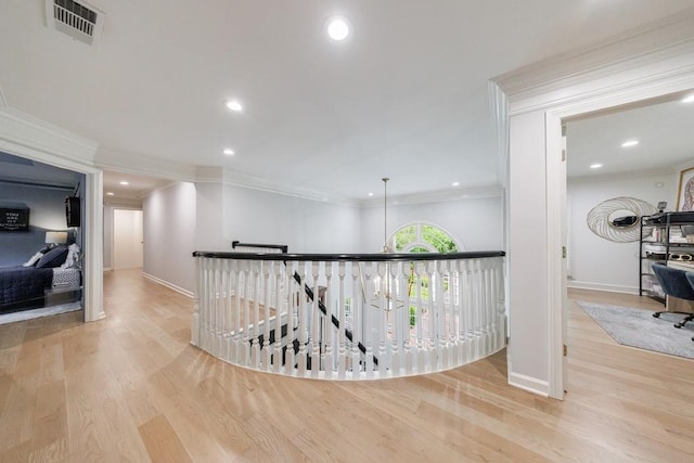 hall with visible vents, ornamental molding, and wood finished floors