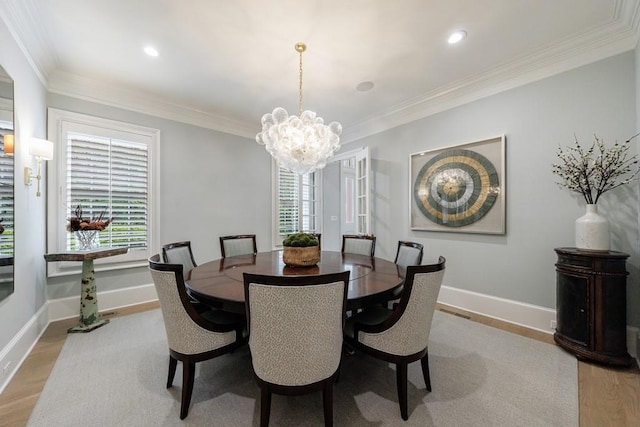 dining space featuring baseboards, ornamental molding, light wood-type flooring, and a notable chandelier
