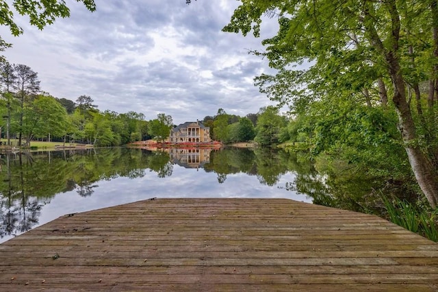 dock area with a water view and a view of trees