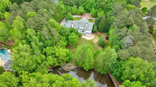 birds eye view of property featuring a water view and a view of trees