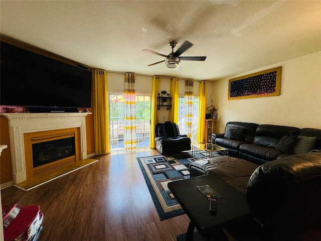 living room featuring dark wood-type flooring and ceiling fan