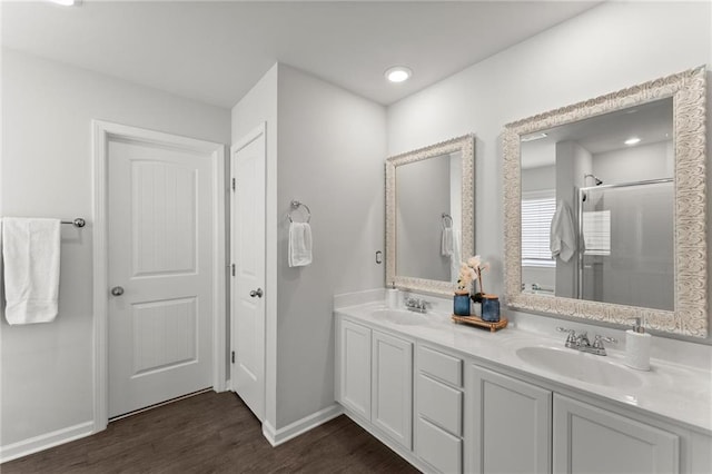34 Hemlock Gln, Dallas, GA 30132 - bathroom featuring wood finished floors, a shower stall, baseboards, and double vanity
