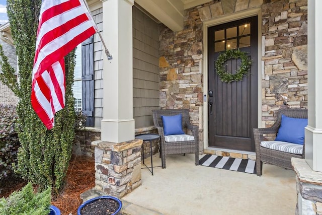 entrance to property with covered porch and stone siding