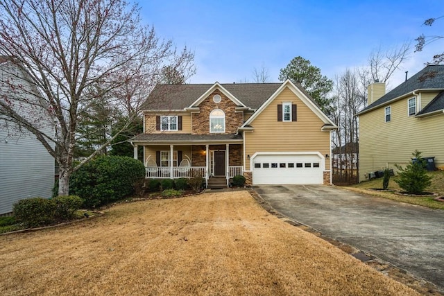 view of front of house with stone siding, a porch, driveway, and a garage