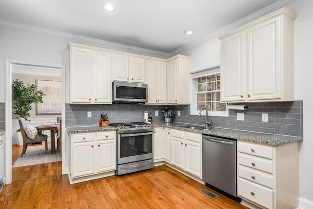 kitchen with visible vents, appliances with stainless steel finishes, light wood-style floors, and a sink