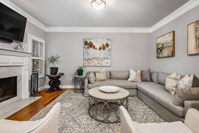 living area with wood finished floors, baseboards, a high end fireplace, and ornamental molding