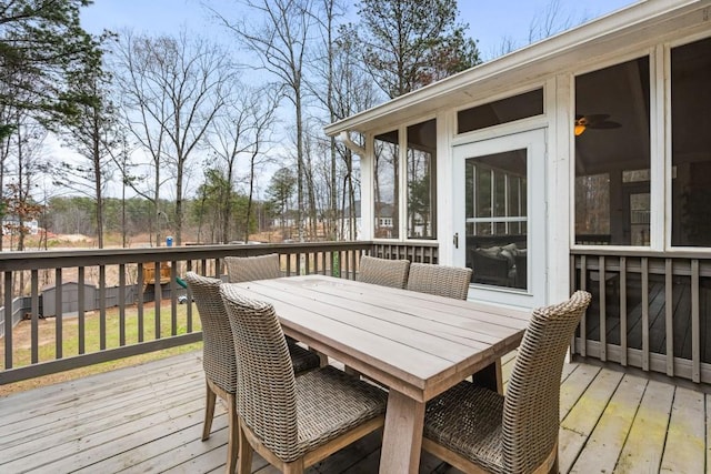 deck featuring outdoor dining area and a sunroom