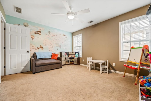 game room with visible vents, light colored carpet, a ceiling fan, and baseboards