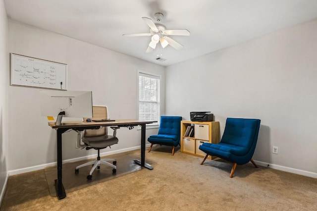 office area featuring light carpet, visible vents, a ceiling fan, and baseboards