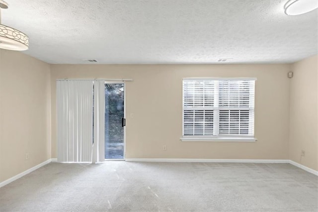 carpeted empty room with a textured ceiling