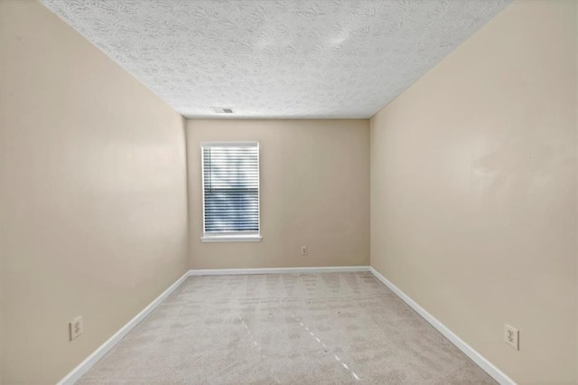 carpeted empty room with a textured ceiling