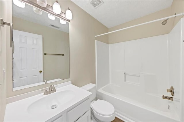 full bathroom featuring a textured ceiling, vanity, toilet, and shower / washtub combination