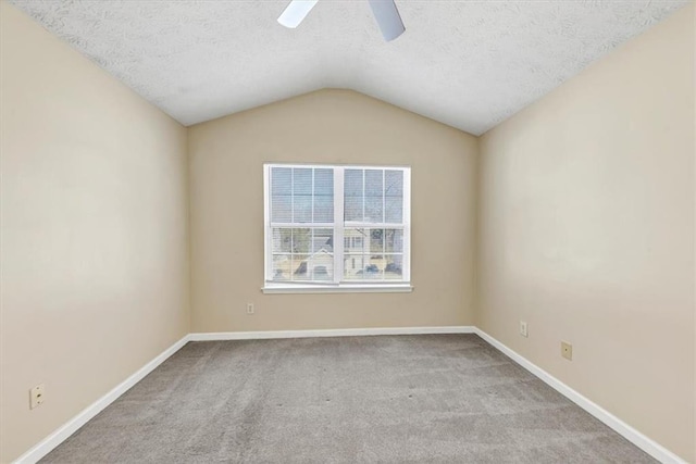 empty room with lofted ceiling, ceiling fan, light carpet, and a textured ceiling