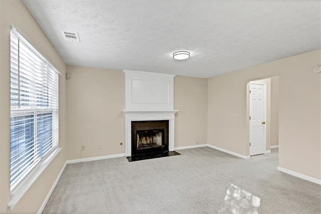 unfurnished living room featuring light carpet and a textured ceiling