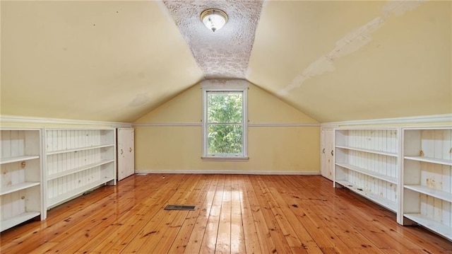 additional living space with lofted ceiling and light wood-type flooring