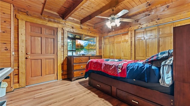 bedroom featuring wood walls, wooden ceiling, ceiling fan, beam ceiling, and light hardwood / wood-style floors