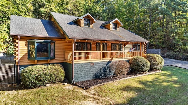 log home featuring covered porch and a front lawn