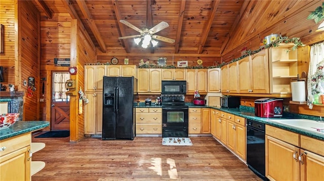 kitchen featuring hardwood / wood-style floors, vaulted ceiling with beams, wood walls, and black appliances