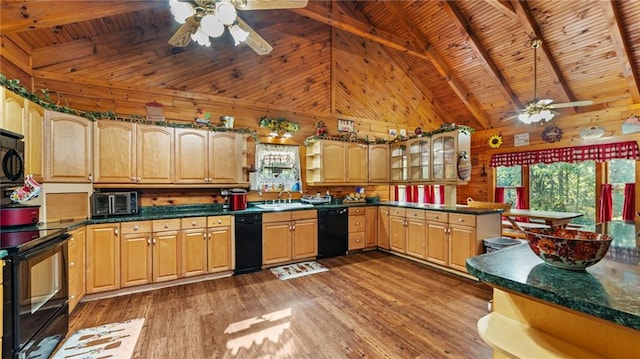 kitchen with wood walls, black appliances, and dark hardwood / wood-style floors