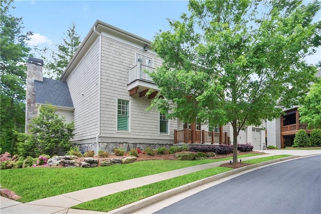 view of front facade featuring a chimney, driveway, and a front yard