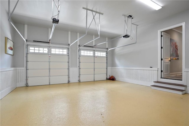 garage with a garage door opener and a wainscoted wall