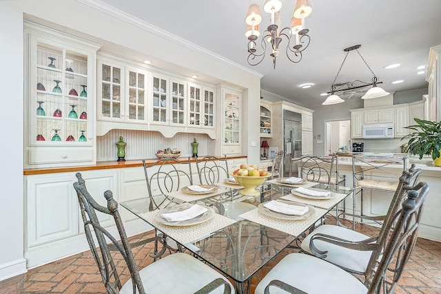 dining room with a notable chandelier and ornamental molding