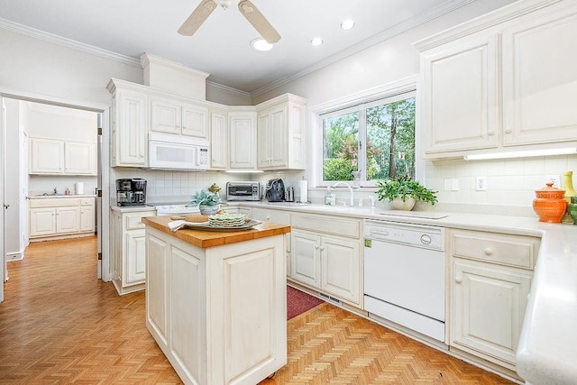 kitchen featuring white appliances, backsplash, butcher block counters, a kitchen island, and light parquet flooring