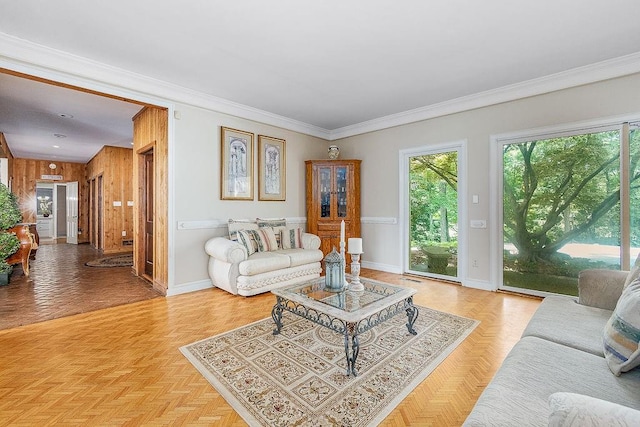 living room featuring wood walls, light parquet floors, and crown molding