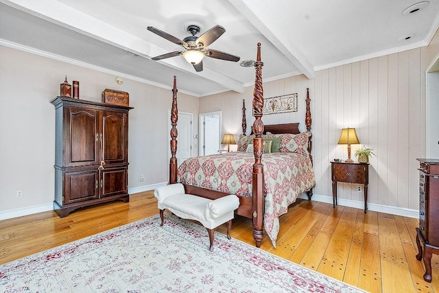 bedroom featuring crown molding, beamed ceiling, light wood-type flooring, and ceiling fan