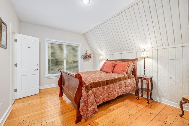 bedroom with vaulted ceiling and hardwood / wood-style floors