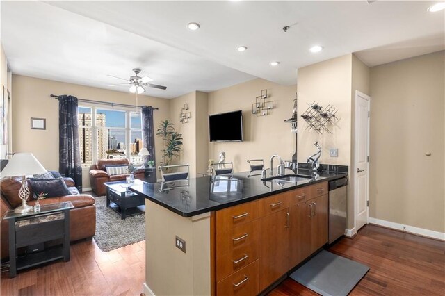 kitchen featuring stainless steel dishwasher, ceiling fan, dark wood-type flooring, and sink