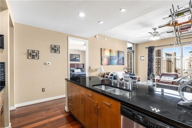 kitchen featuring dark hardwood / wood-style floors, stainless steel dishwasher, ceiling fan, and sink