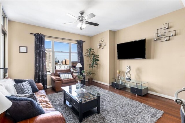 living room with ceiling fan and dark wood-type flooring