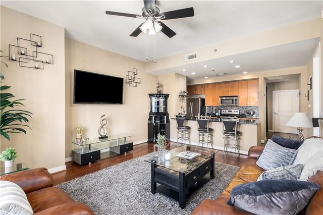 living room featuring ceiling fan and dark hardwood / wood-style flooring