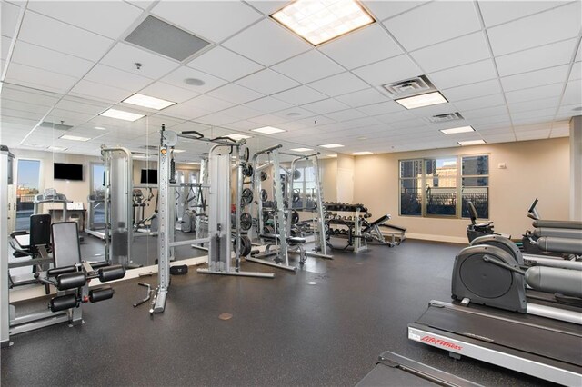 exercise room featuring a drop ceiling and plenty of natural light