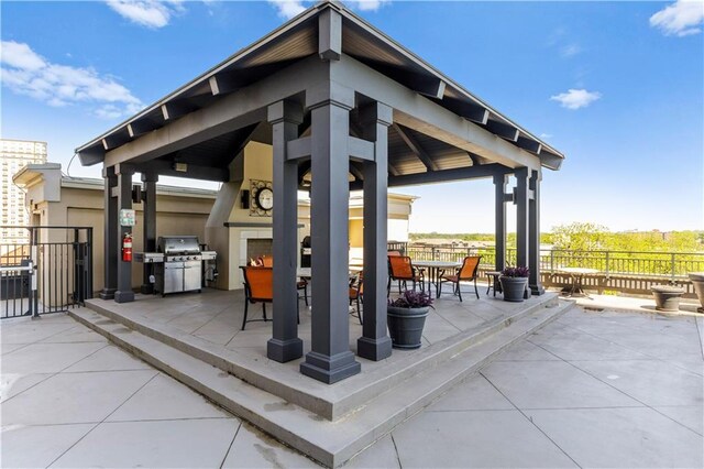 view of patio featuring a gazebo, area for grilling, and an outdoor fireplace