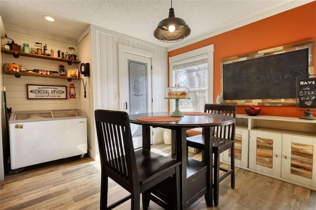 dining area featuring a textured ceiling and light hardwood / wood-style floors