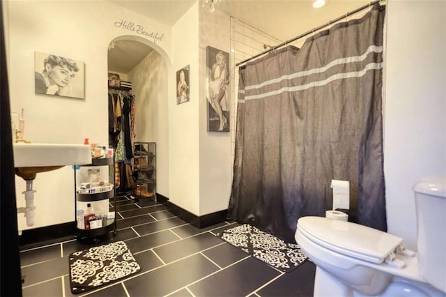 bathroom with toilet and a shower with shower curtain