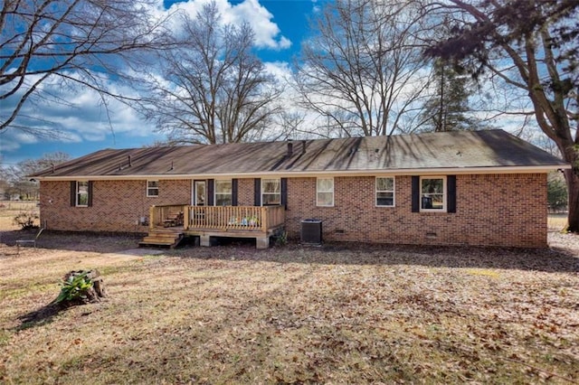 rear view of house with central AC unit, a yard, and a deck