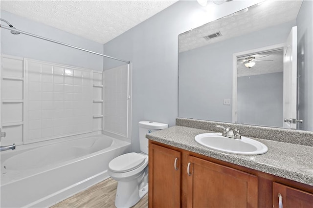 full bathroom with vanity, shower / tub combination, ceiling fan, toilet, and a textured ceiling