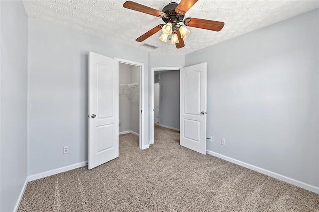 unfurnished bedroom featuring light carpet, a textured ceiling, and ceiling fan