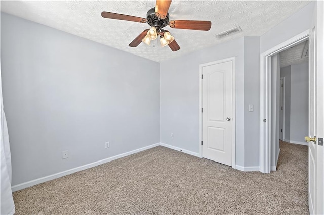 unfurnished bedroom featuring light carpet, a textured ceiling, a closet, and ceiling fan