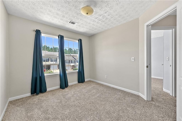 carpeted spare room with a textured ceiling