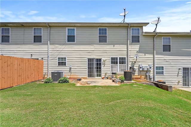 rear view of property with a yard, cooling unit, and a patio area