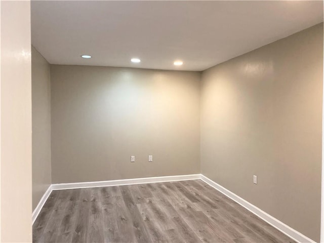 spare room with baseboards, recessed lighting, and wood finished floors