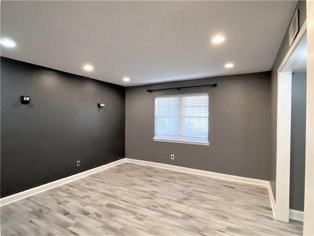 empty room with recessed lighting, baseboards, and light wood-type flooring