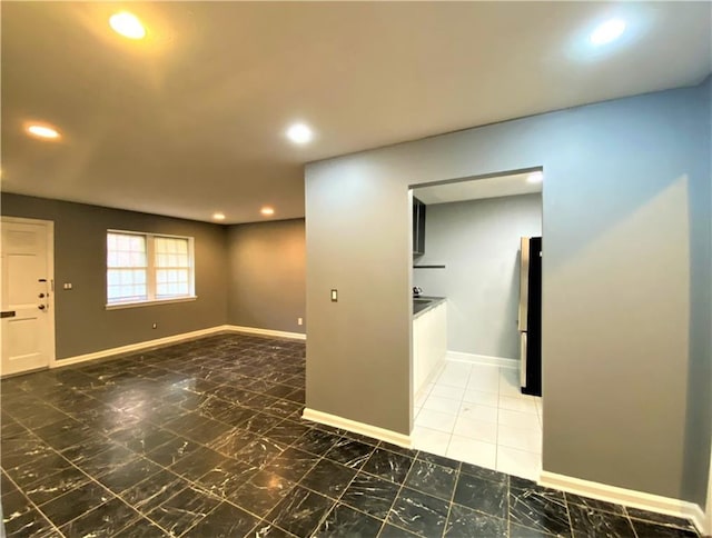 empty room featuring recessed lighting, baseboards, and marble finish floor