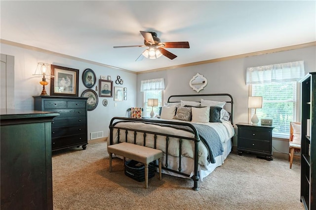 carpeted bedroom with ceiling fan and crown molding